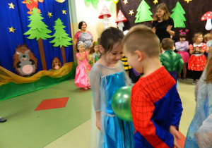 Dzieci tańczą w rytm muzyki z balonem trzymając go brzuszkami