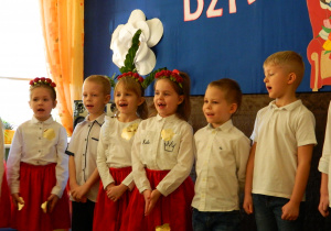 Dziewczynki i chłopcy śpiewaja piosenkę.
