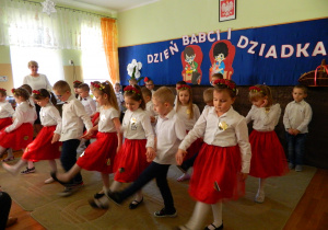 Dzieci unoszą nogi w tańcu.