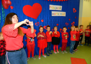 Pani Gabrysia wraz z dziećmi pokazuje serce z rąk.
