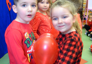Dzieci tącza w parach z balonem w kształcie serduszka.