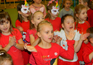 Dziewczynki spiewają i klaszczą w ręce.