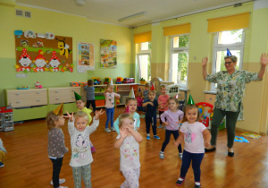 Pani Lucynka z z dziećmi z grupy pierwszej tańczy do muzyki przedszkolnej.