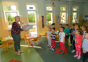Dzieci z grupy Biedronek oglądają upominki z okazji Dnia Przedszkolaka prezentowane prze pania Dyrektor