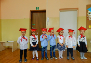 Widok chłopców i dziewczynek w czerwonych czapeczkach