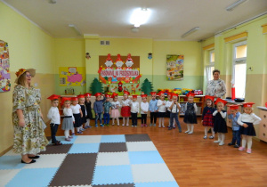 Dzieci z grupy Krasnali wraz z wychowawczyniami stoją na tle dekoracji