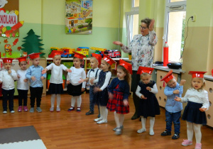Dzieci razem z panią Lucynką śpiewają piosenkę i pokazują do jej słów