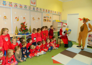 Mikołaj pokazuje dzieciom prezenty