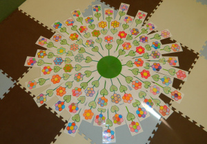 Koło ułożone z kolorowych kwiatów zrobionych przez dzieci