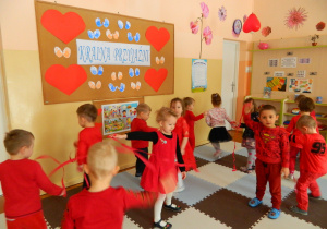 Dzieci z grupy Wiewiórek tańczą z czerwonymi wstążkami