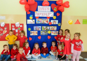 Dzieci z grupy Krasnali stoją na tle dekoracji