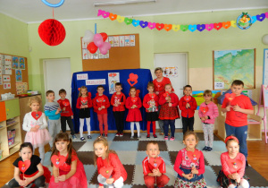 Dzieci z grupy Motylków z panią Grażynką trzymają w ręcha czerwone serca
