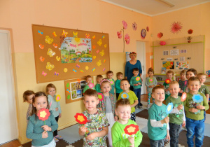 Dzieci zgrupy Wiewiórek z panią Stasią tańczą z kwiatkai w dłoniach