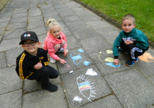 Dzieci z grupy Misiów malują kredą po chodniku