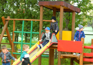 Chłopcy zjeżdżają na ślizgawce w ogrodzie przedszkolnym