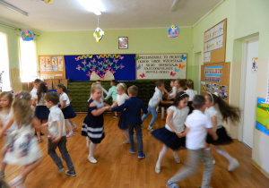 Dzieci tańczą w kółeczkach po trzy osoby