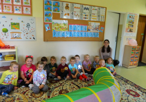 Pani Iza z dziećmi siedzi na dywanie
